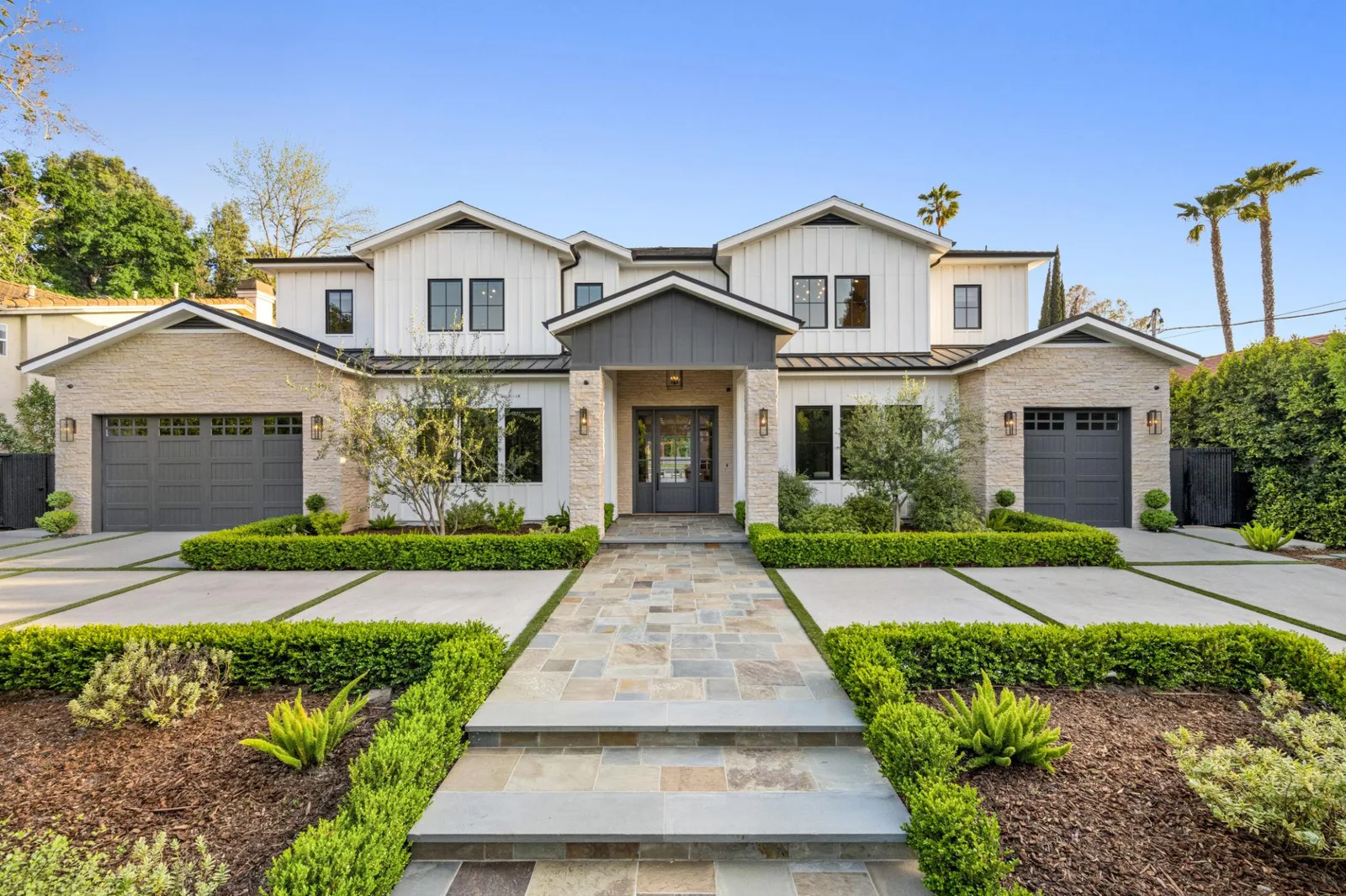 A two-story house photographed from the driveway in daylight before any design work